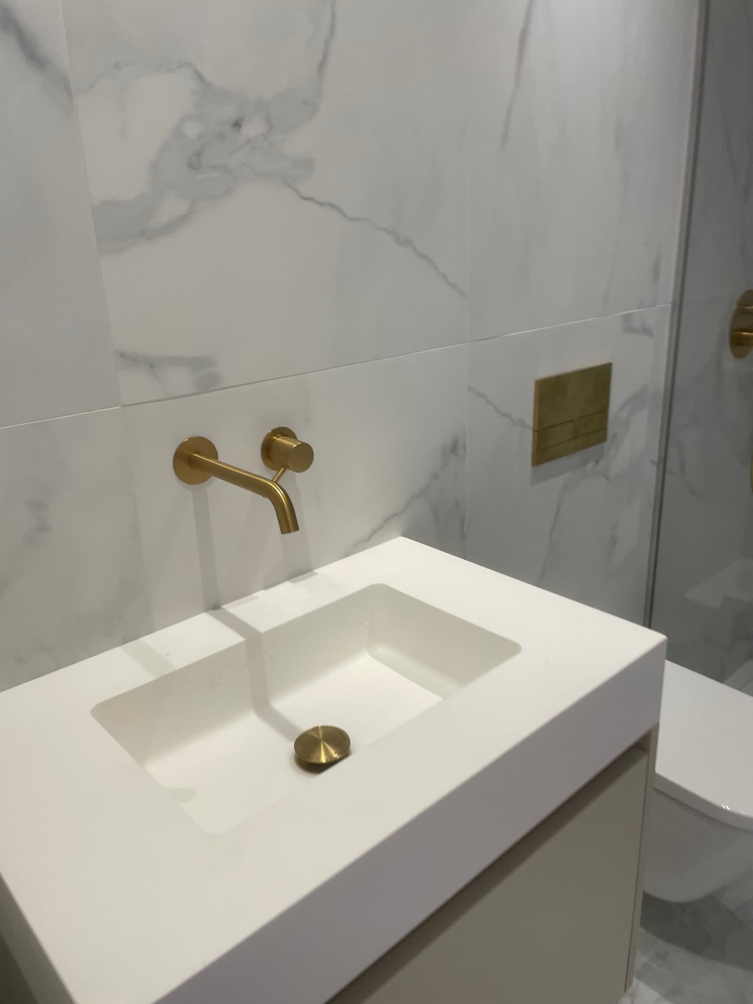 Casa de banho moderna em mármore com torneira e válvulas douradas — trabalho da Paulo Sá