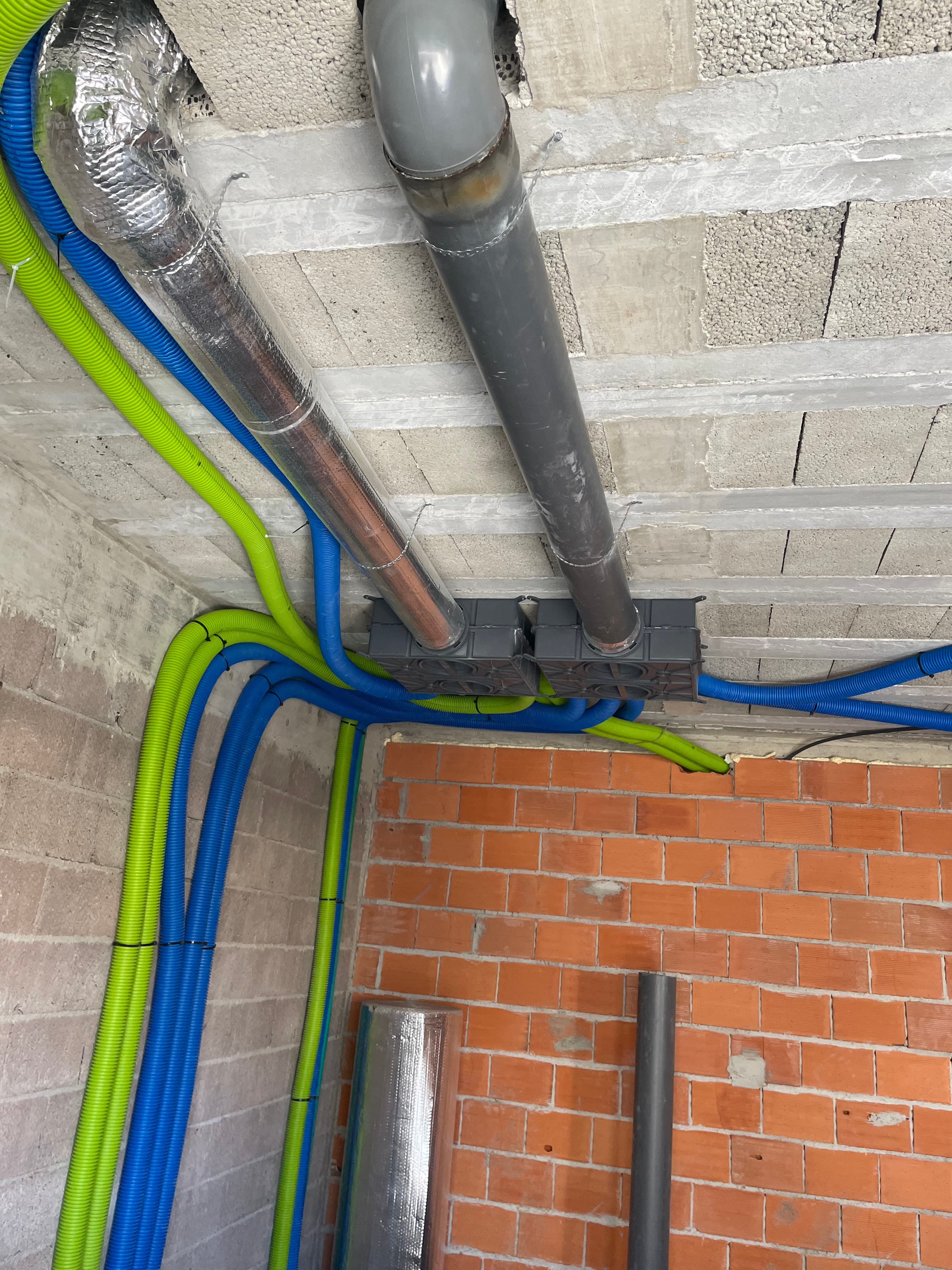 Rede de tubagem de água quente e fria instalada na parede de uma moradia em construção